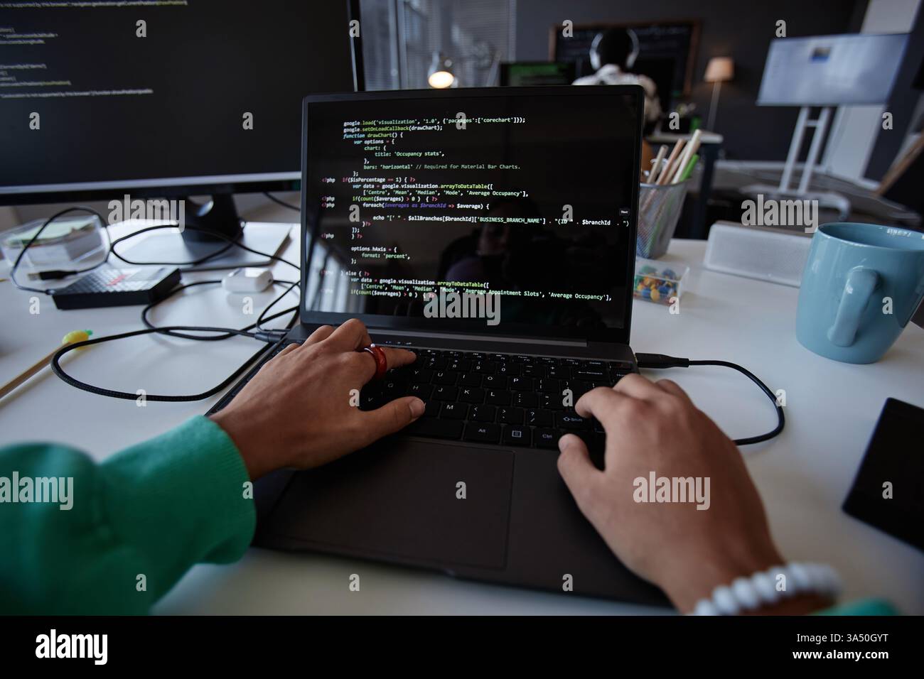 Close-up of programmer typing codes on laptop while sitting at her workplace in IT office Stock Photo
