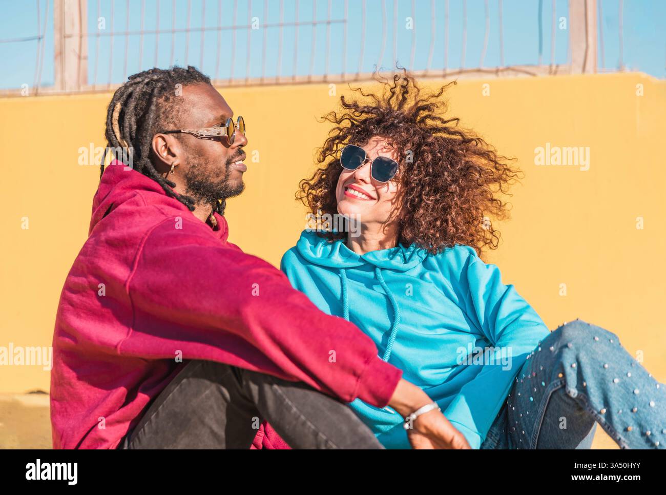 Smiling multiracial couple sits hi-res stock photography and images - Alamy
