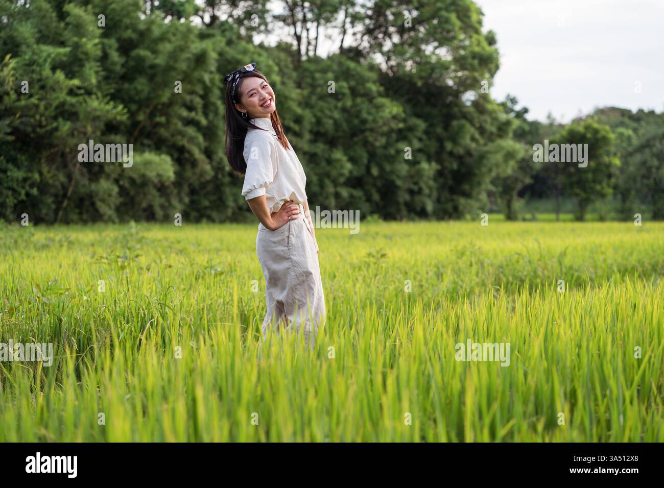 Asian woman standing in rice field while enjoying freedom in summer ...