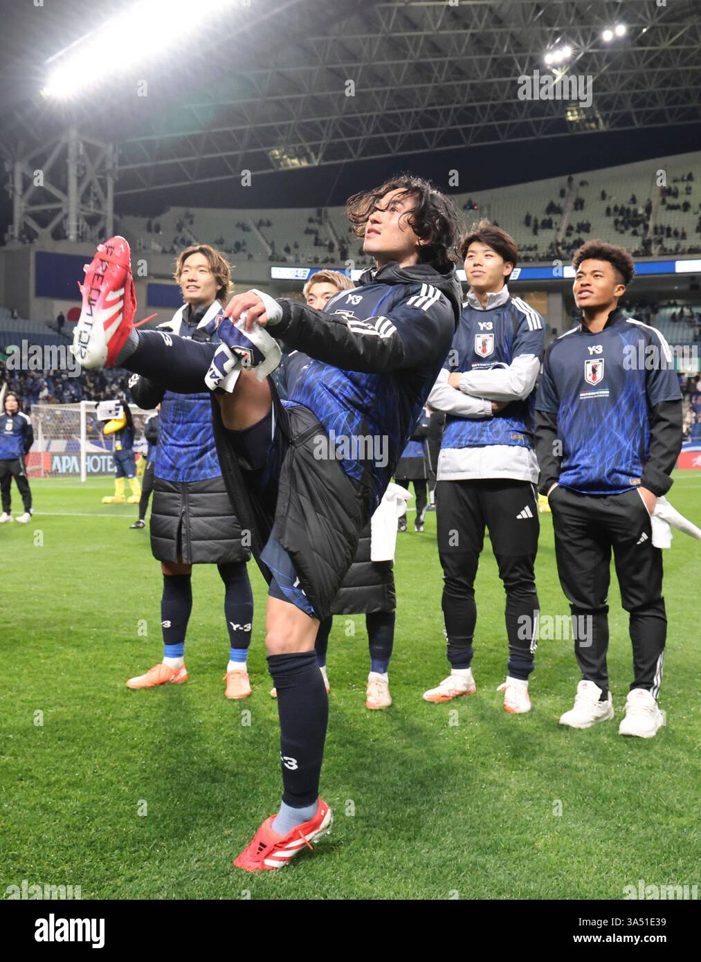 Japan's Takumi Minamino (C) kicks the ball into the stands and responds
