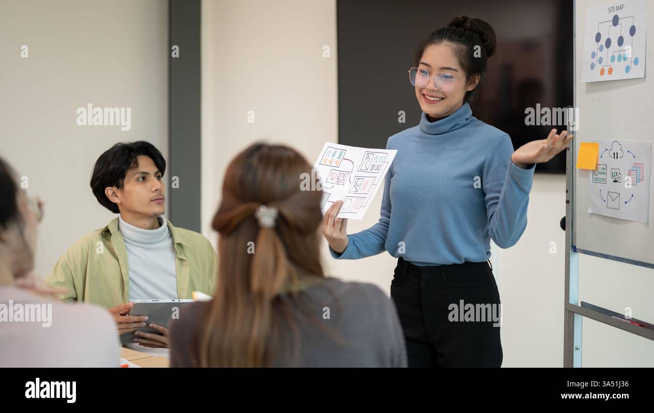 Young smart UX UI designer presenting her idea to the team ...