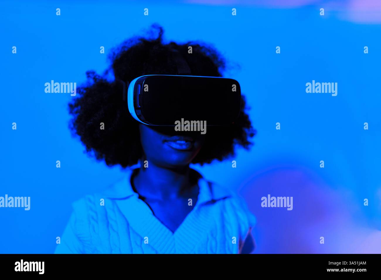 Black woman with afro wearing VR glasses experiencing virtual reality ...