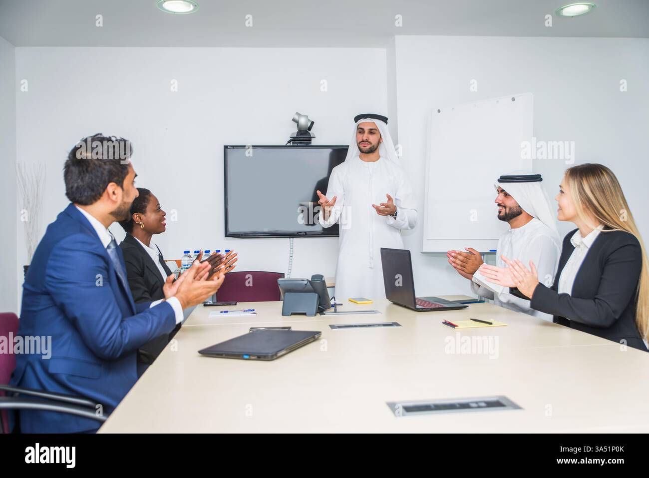 Group Reflecting Diverse group of business people in a UAE meeting room collaborating on ...