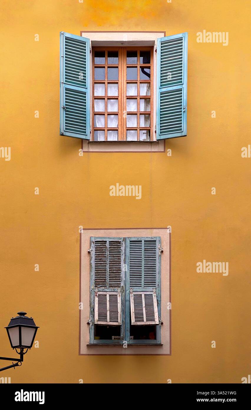 Blue window shutters against a yellow wall - Smartphone Captured Stock Image