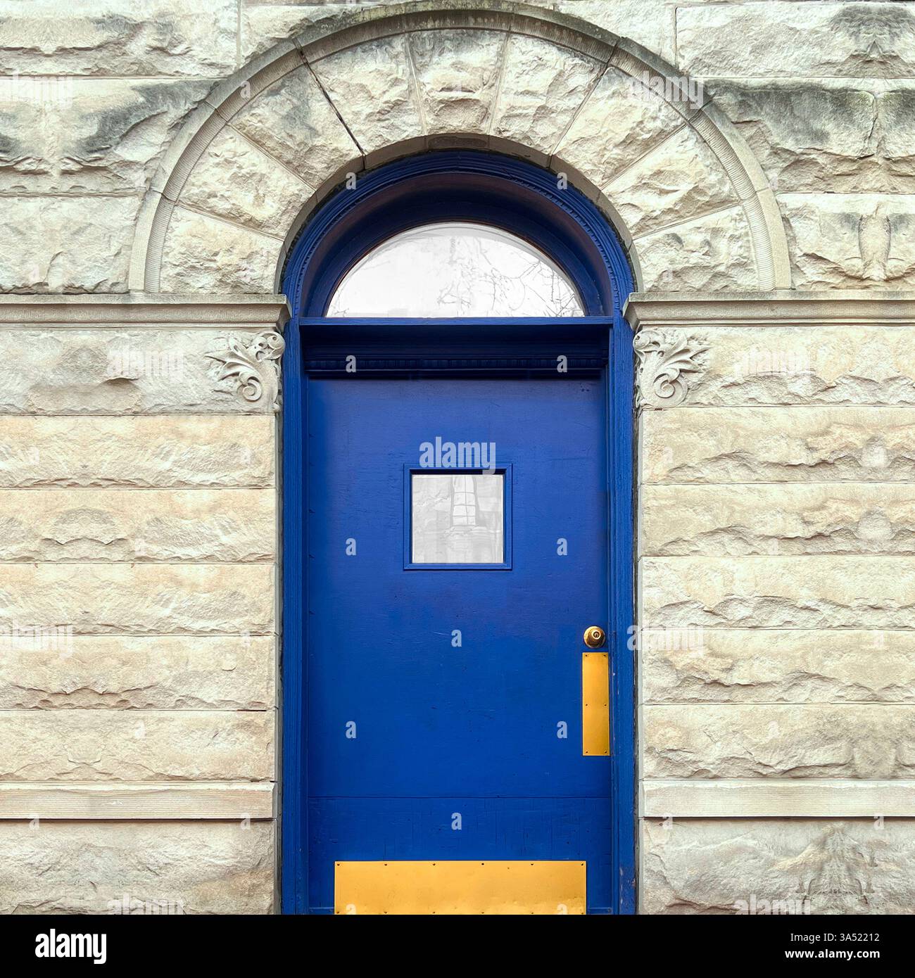 Blue Door with Arched Window in Historic Brick Facade - Smartphone Captured Stock Image