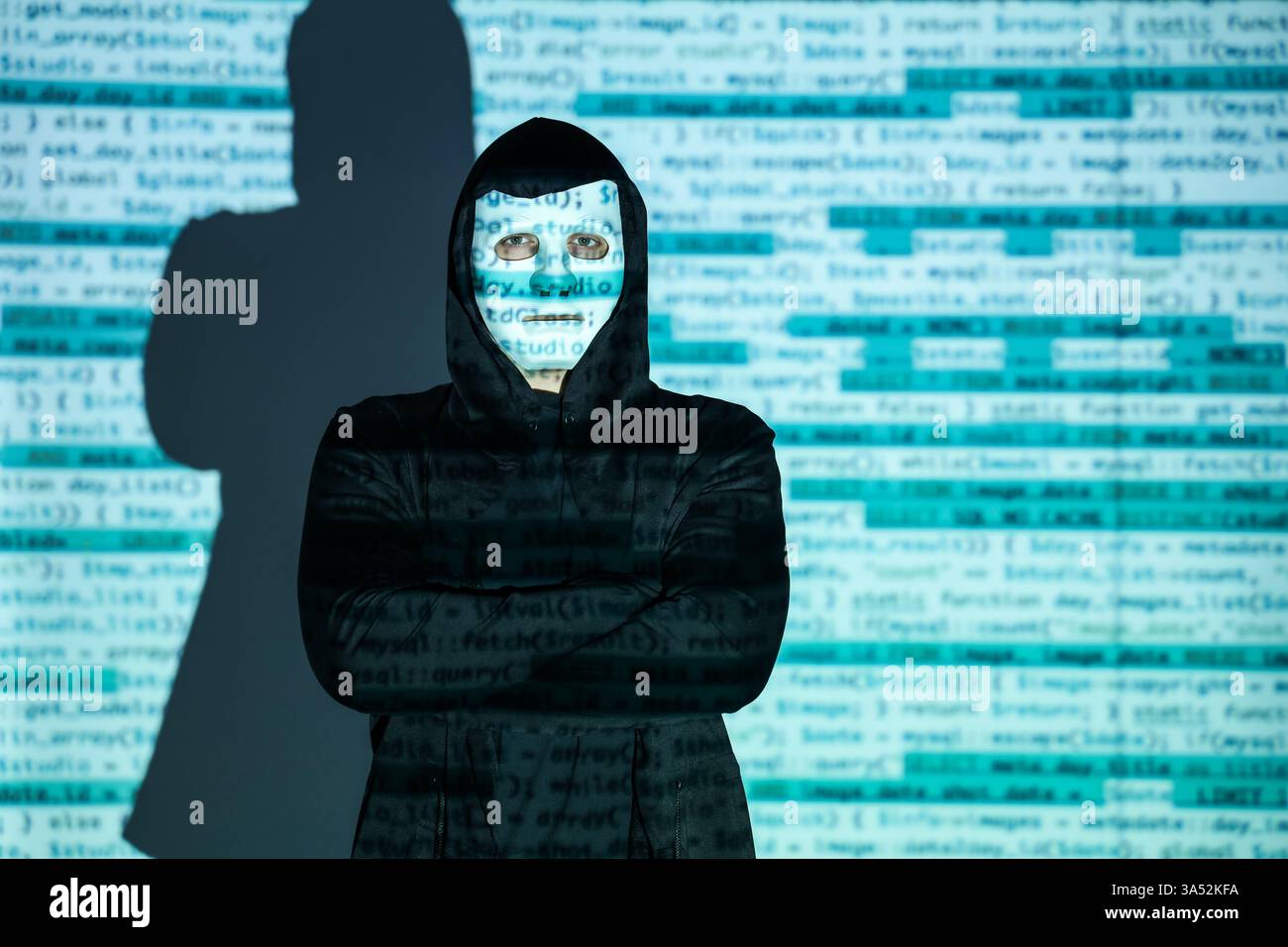 Hacker with projection of programming code in dark room Stock Photo