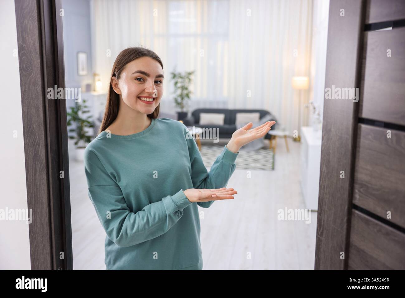 Photo inspiration: Visual Reference: Cheerful Woman Welcoming Guests To Her Apartment Stock Photo
