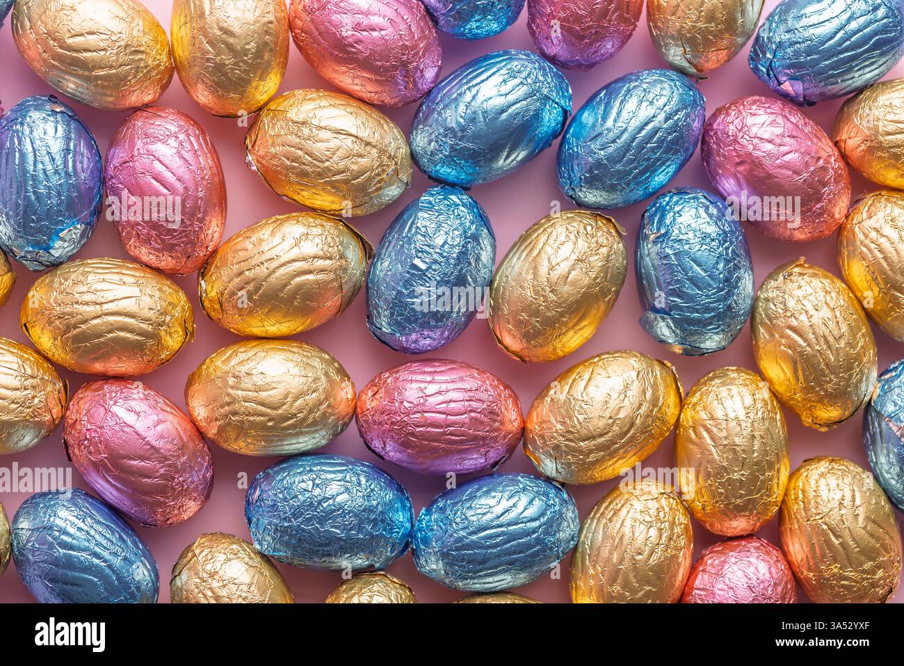 Chocolate easter eggs wrapped in multi colored foil. Top view. Stock Photo