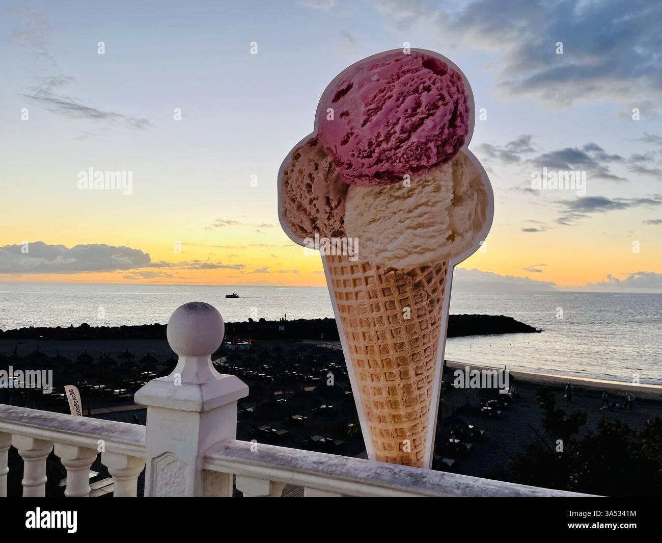 An Ice Cream Sign on the Costa Adeje Seafront Promenade, overlooking Playa de Torviscas. Concept: Holidays, Vacations, Sunset, Beach, Seaside. - Smartphone Captured Stock Image