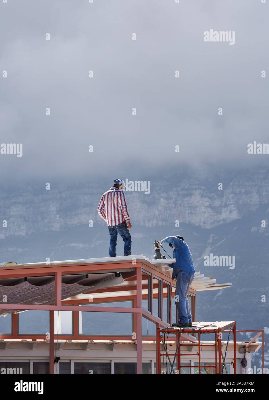 Two workers working on the roof Stock Photo