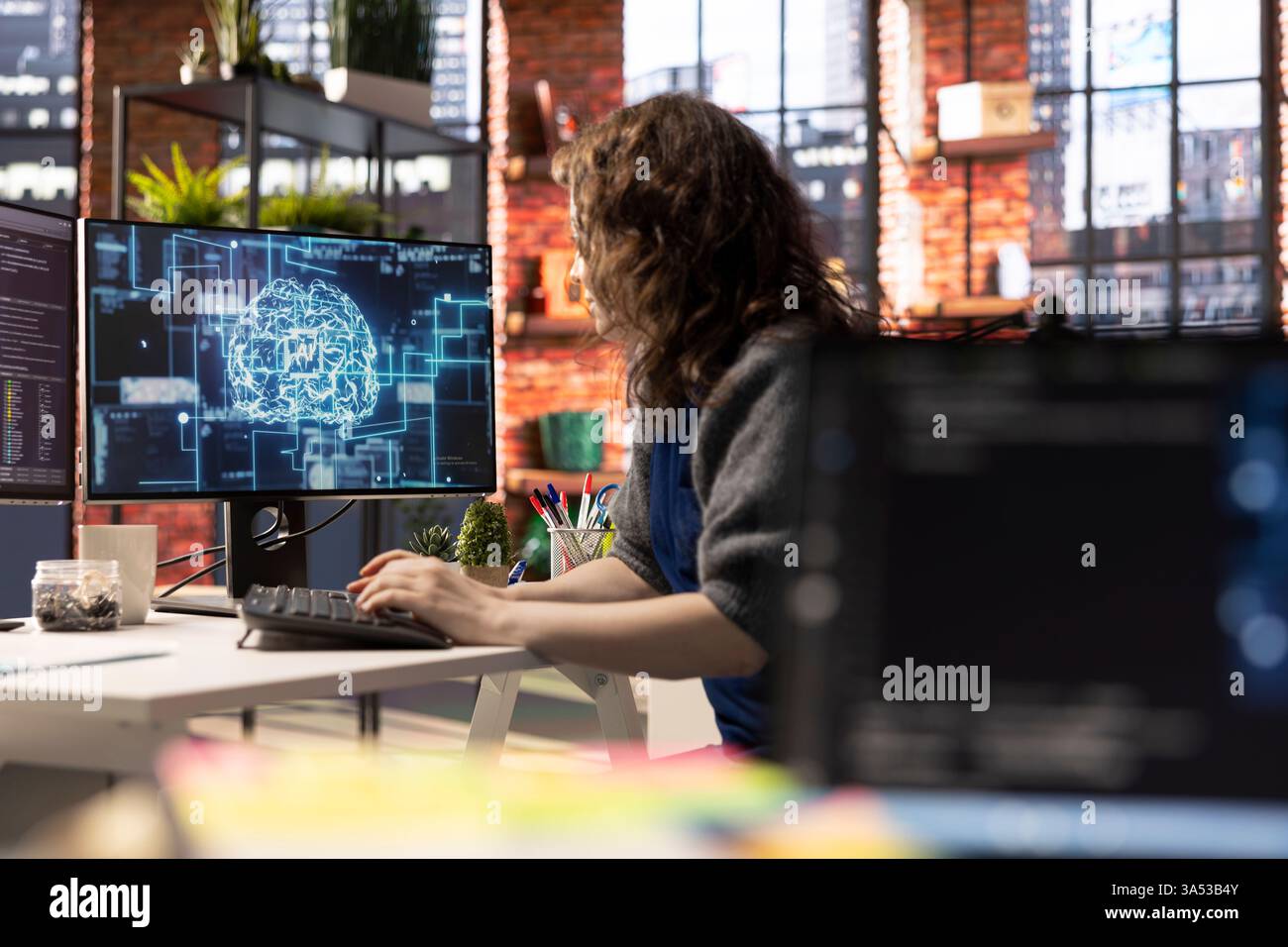Teleworking developer using computer for artificial intelligence computing through self learning algorithms. Agency IT engineer works with AI deep neural networks on desktop PC. Stock Photo