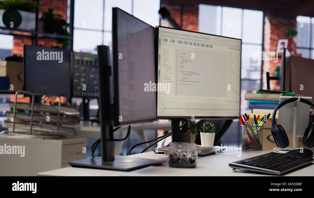 Advanced AI algorithms running on computer monitors in empty startup workspace deploying machine learning models. Coding platform on PC screens in Silicon Valley office, close up shot Stock Photo