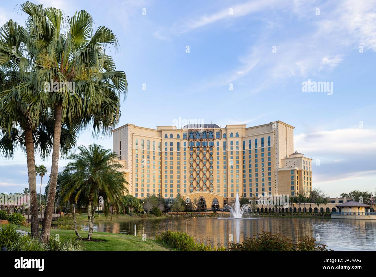 Gran Destino Tower at Disney’s Coronado Springs Resort framed by palm trees beside Lago Dorado, Lake Buena Vista, Florida. Stock Photo