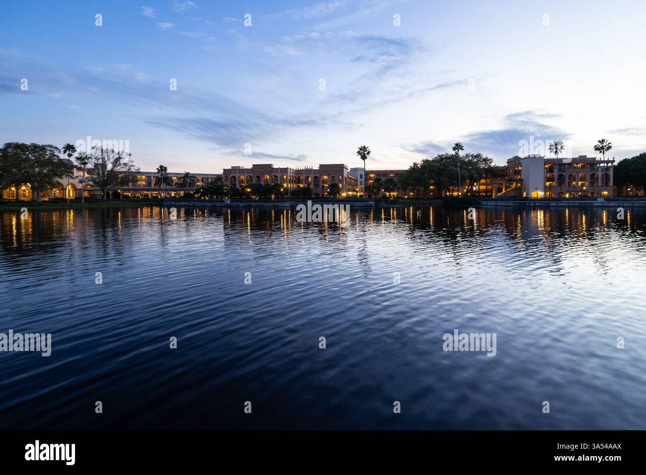 Evening view of Disney’s Coronado Springs Resort reflected in Lago Dorado at dusk, Lake Buena Vista, Florida. Stock Photo