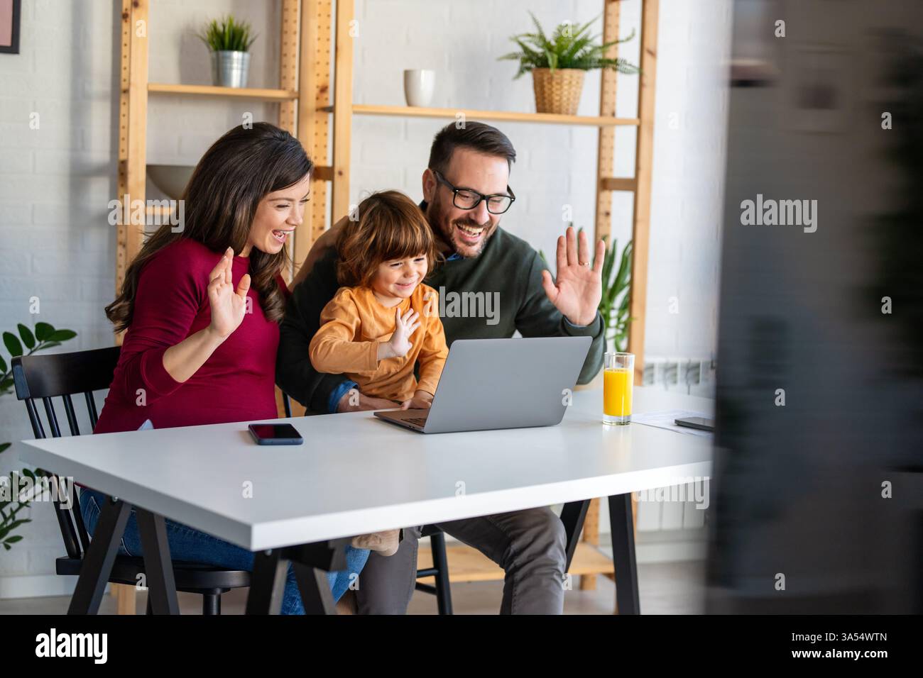 Parents Using Computer Parents and child relaxing at home with computer watching funny ...