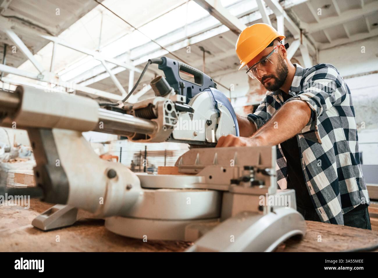 Focused, woodworking. Man is in warehouse. Stock Photo