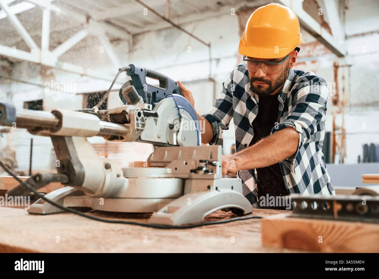 Focused, woodworking. Man is in warehouse. Stock Photo