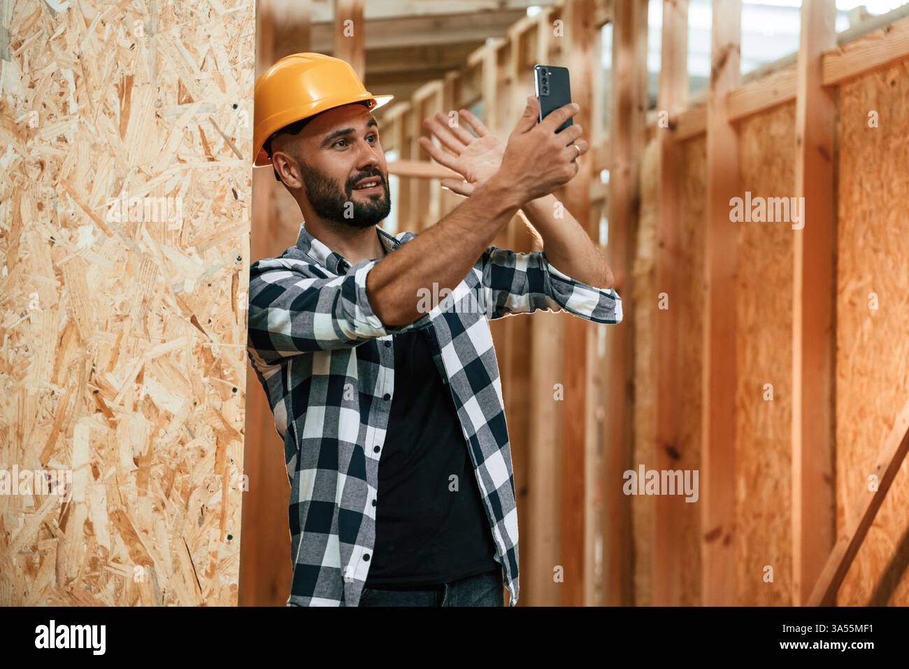 Worker Using Smartphone Using the smartphone. Industrial worker in wooden warehouse Stock Photo ...