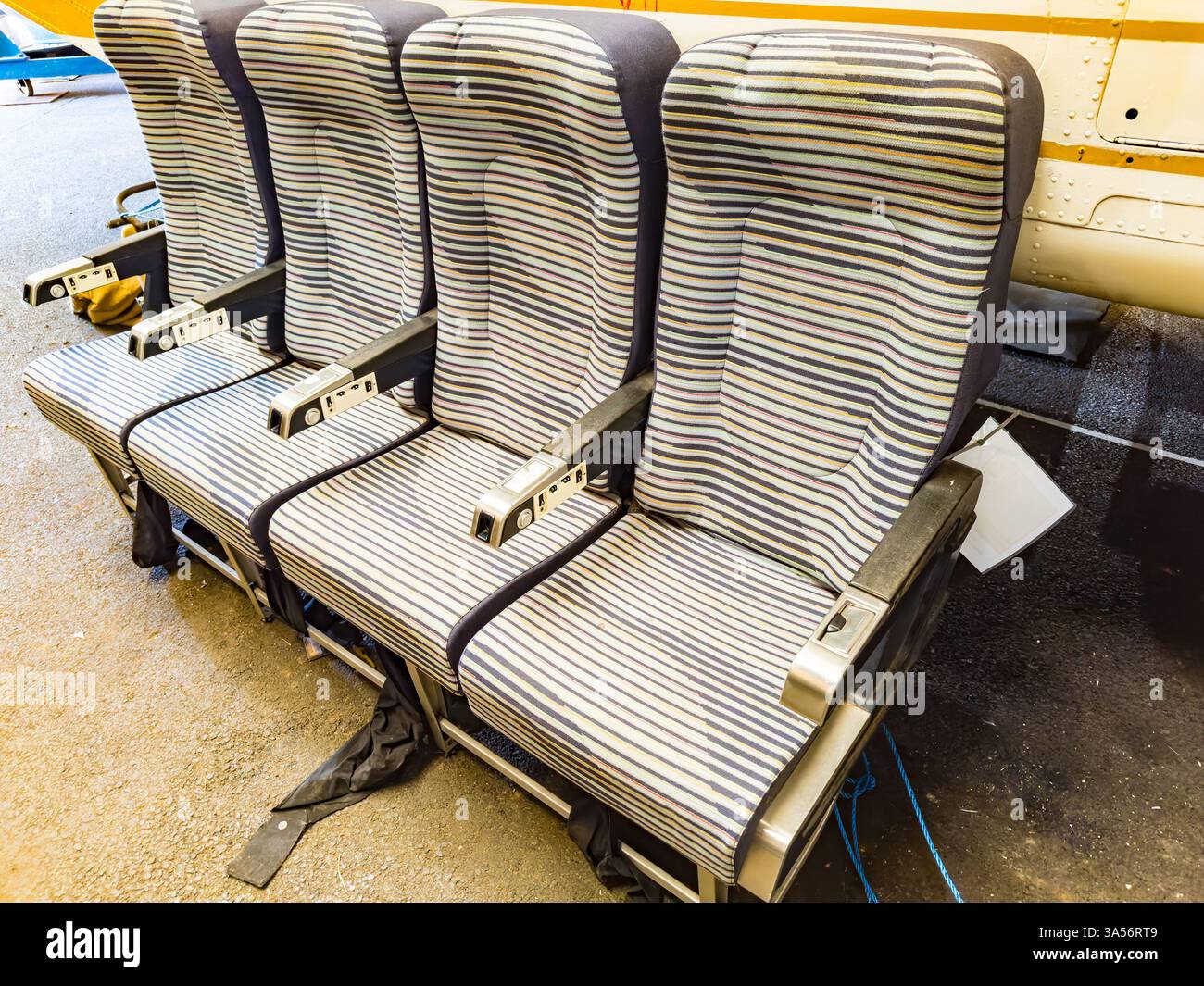 row of 4 1960s & 1970s vintage fabric covered aircraft seats in stripes