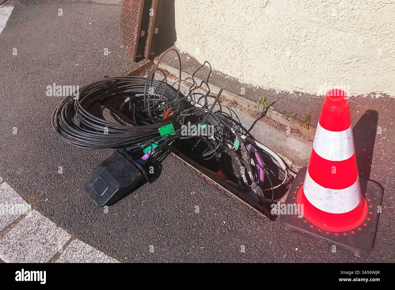 Maintenance or intallation work on buried underground optic fiber cables and lines for the internet network in a city street Stock Photo