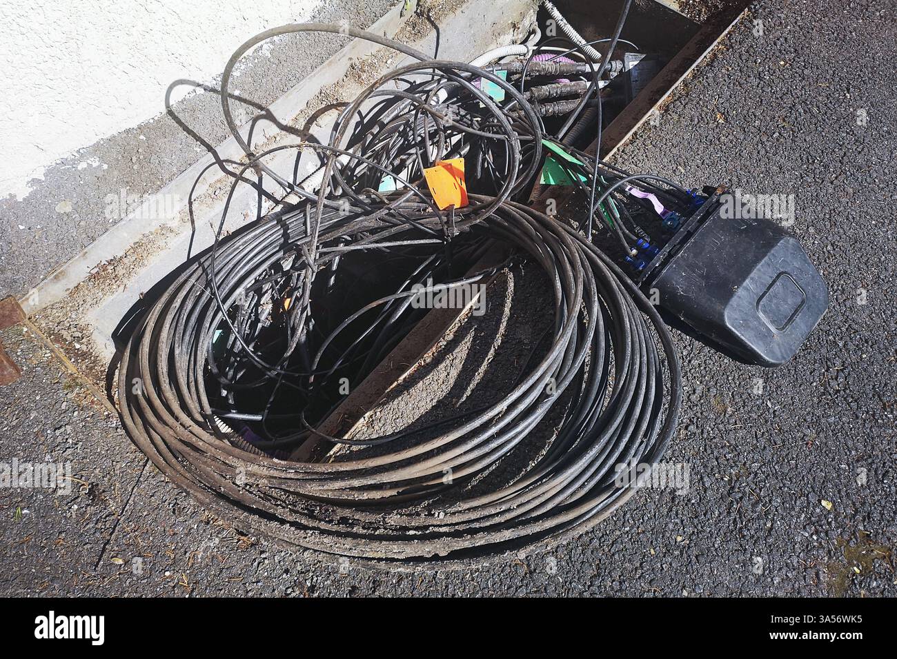 Maintenance or intallation work on buried underground optic fiber cables and lines for the internet network in a city street Stock Photo