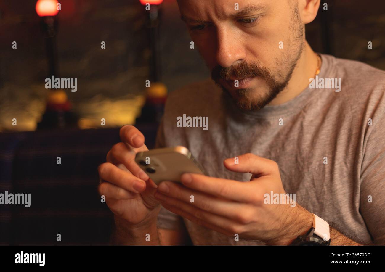 Serious young man using phone Stock Photo