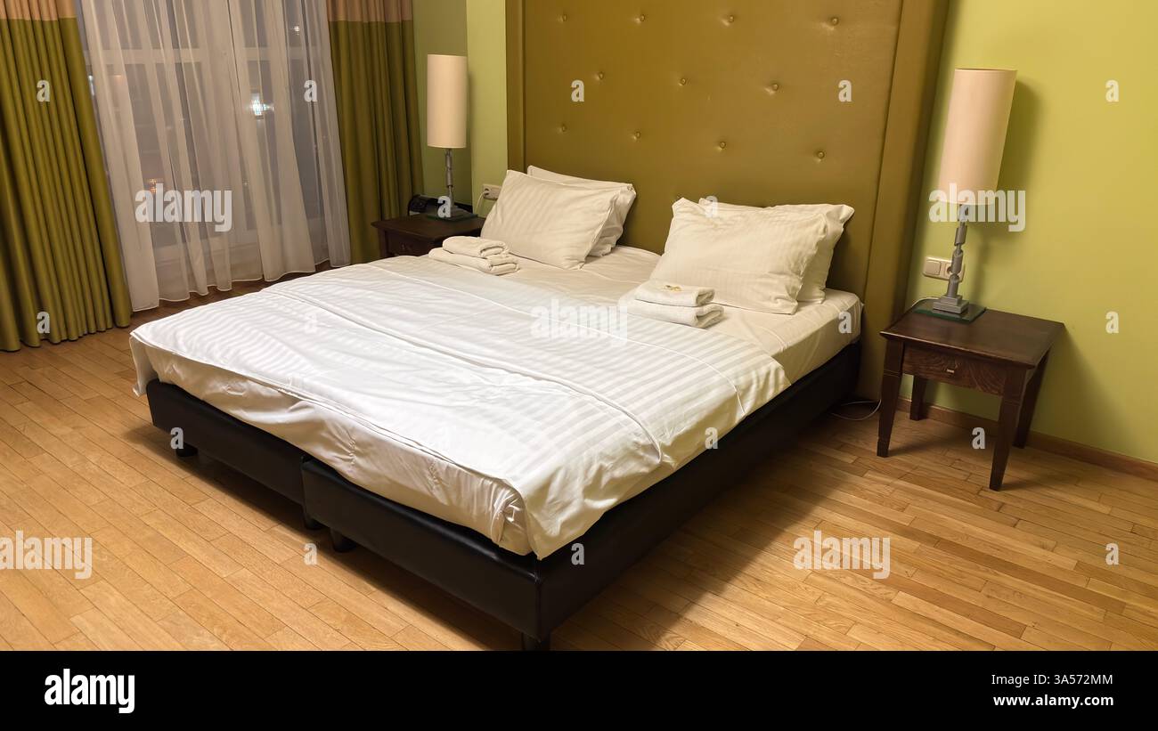 interior design of hotel bedroom, modern furniture, big bed. Towels and pillows. Large headboard - Smartphone Captured Stock Image