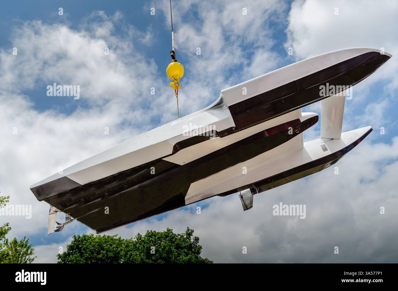 Hydroplane racing boat being lifted out of the water and moved overhead ...