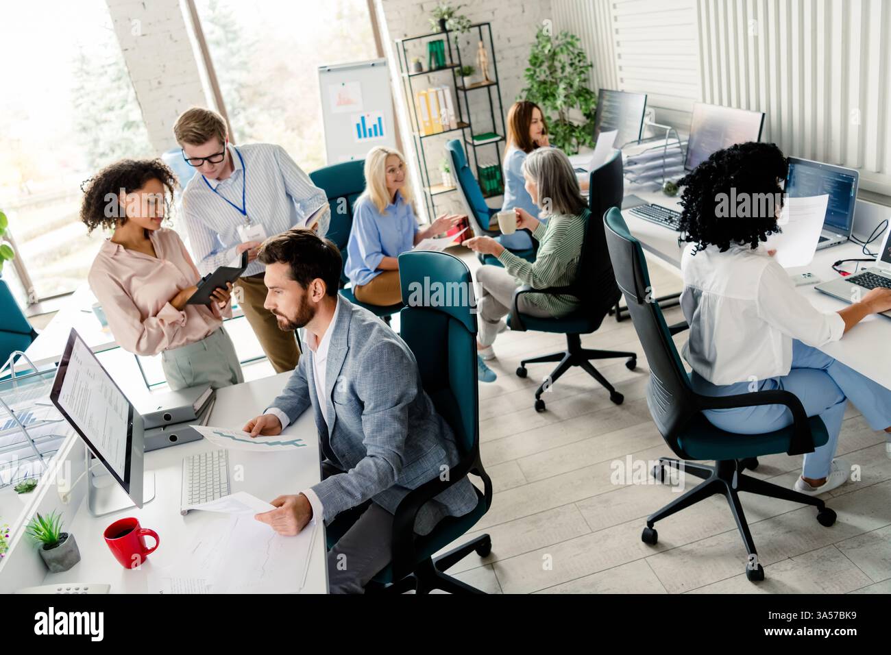 Diverse group of professionals collaborating and working in a coworking ...