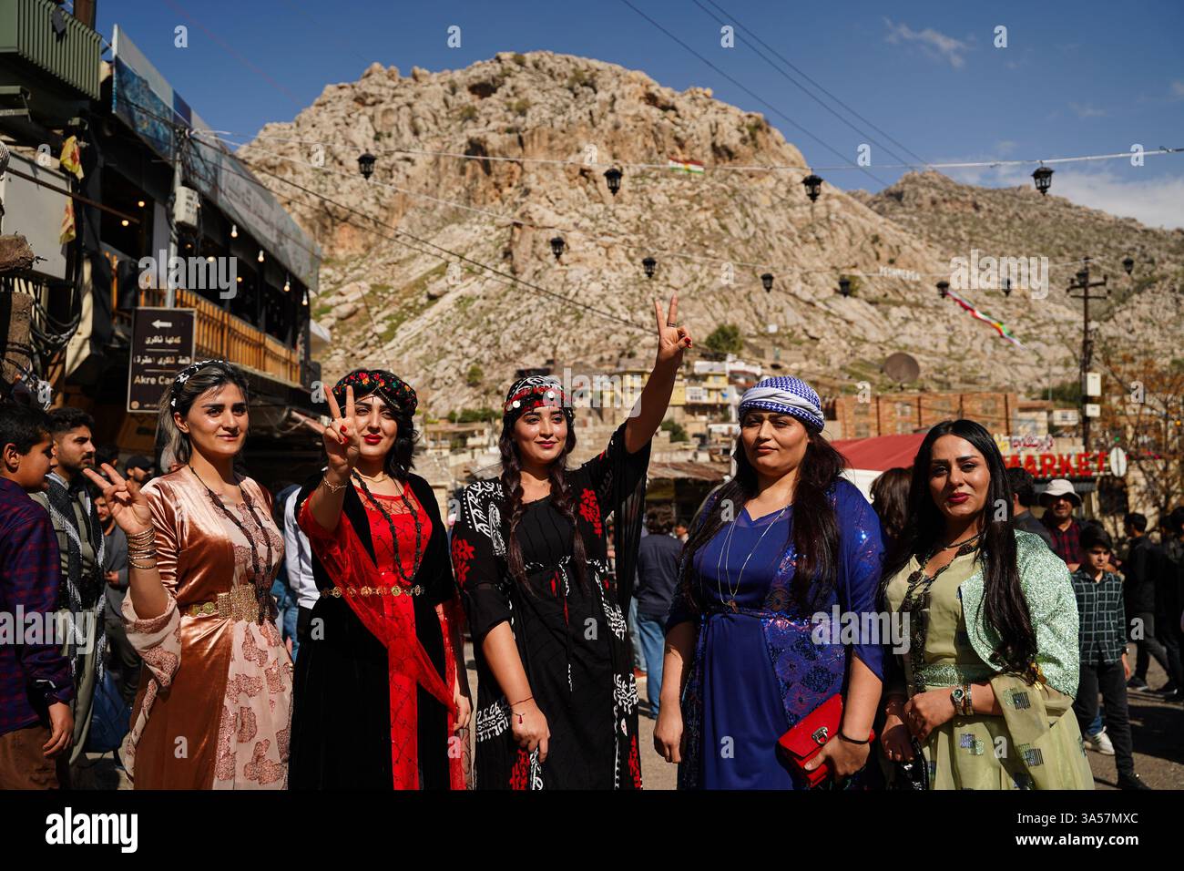 Iranian Kurdish women wearing traditional clothes wave the victory sign ...