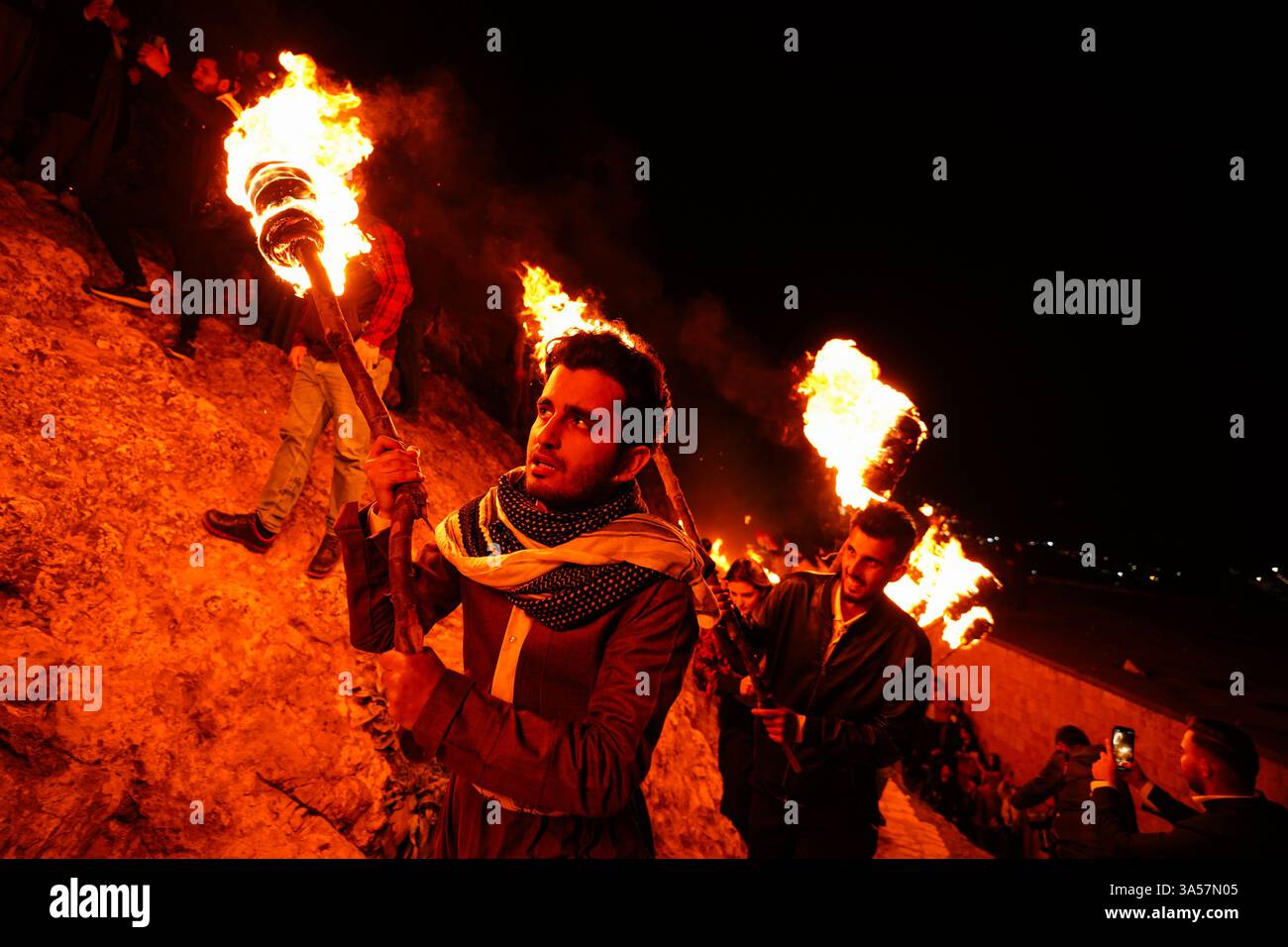 Iraqi Kurds carry fire torches as they celebrate Nowruz Day, a festival ...