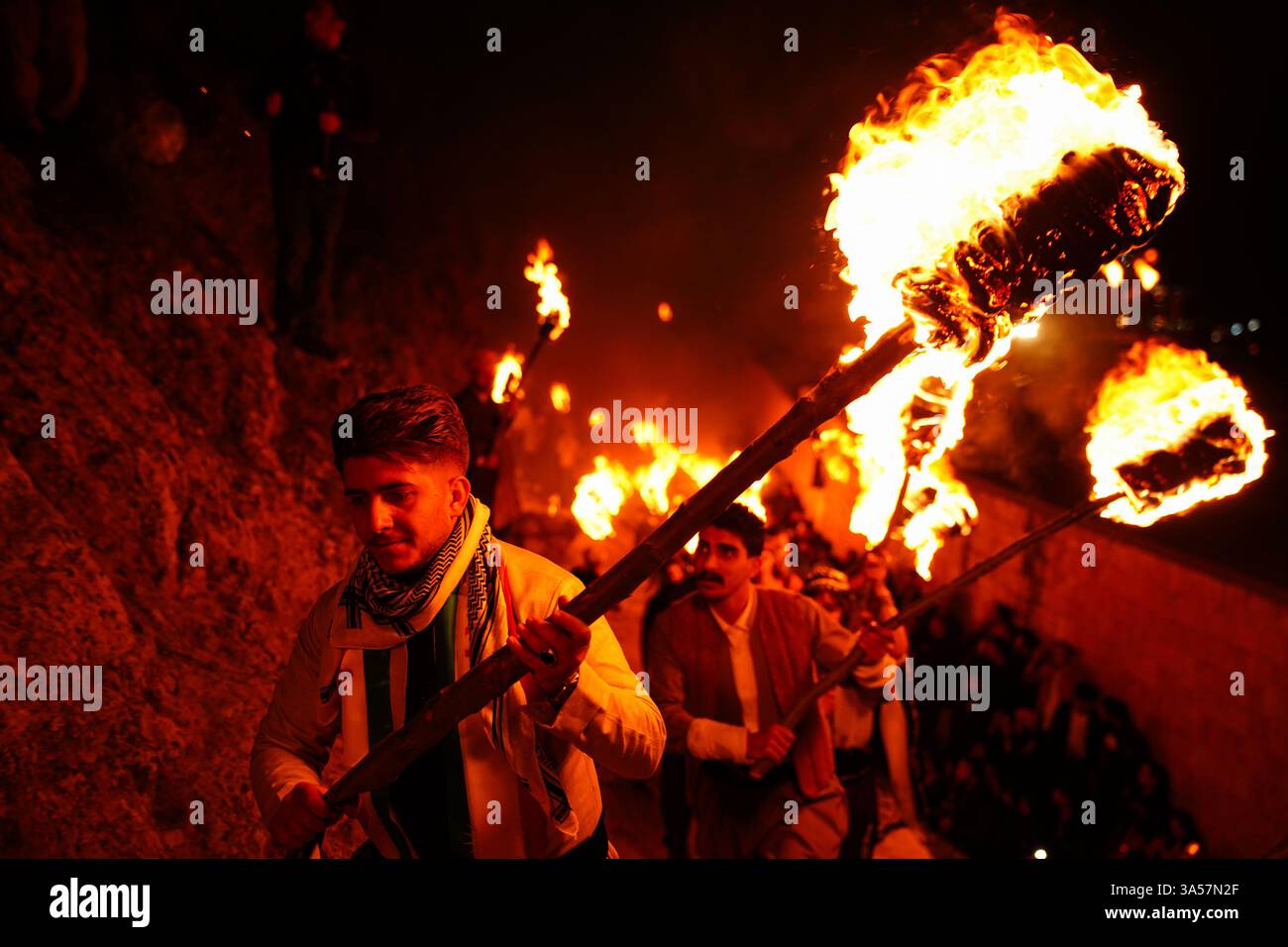 An Iraqi Kurdish man carries a fire torch as people celebrate Nowruz ...
