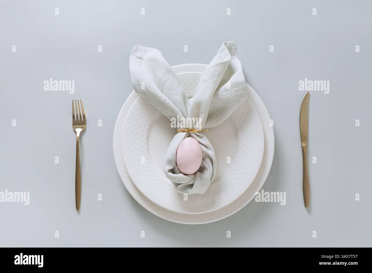 Easter spring table setting with pink egg on gray background. Happy creative Easter decoration. View from above. Stock Photo