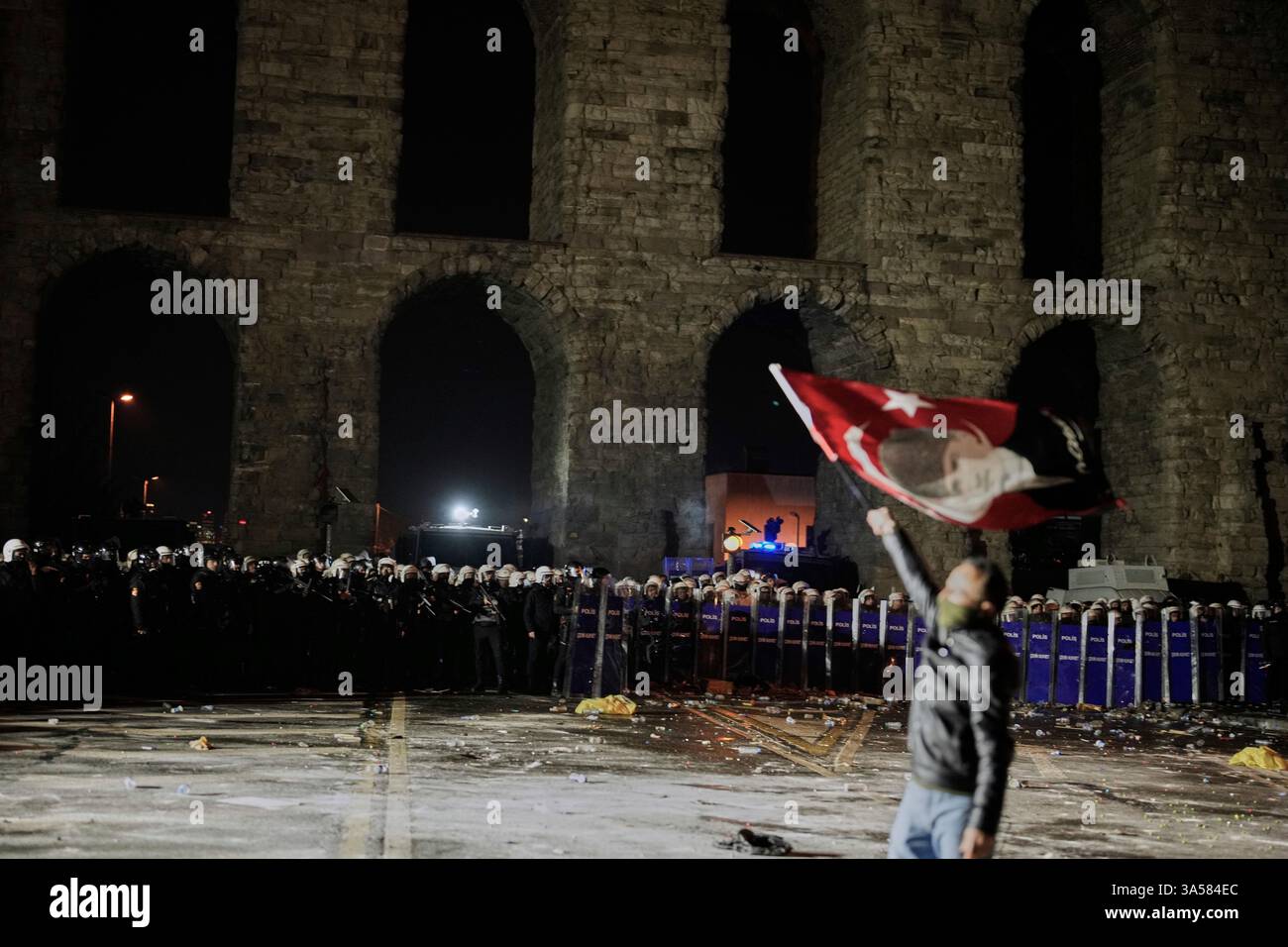 A man holds a Turkish flag with the image of Turkey's founding father ...