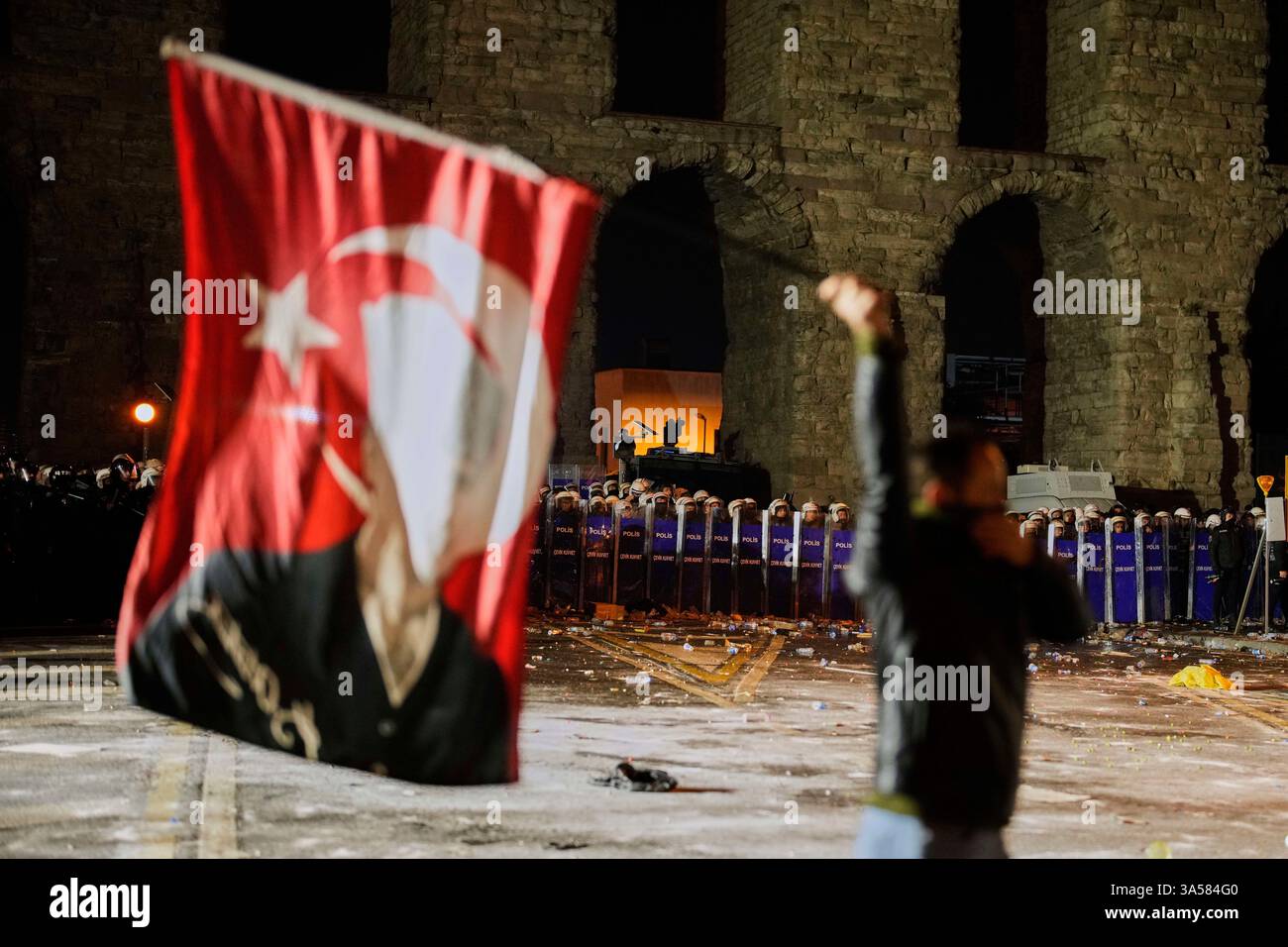 A man holds a Turkish flag with the image of Turkey's founding father ...