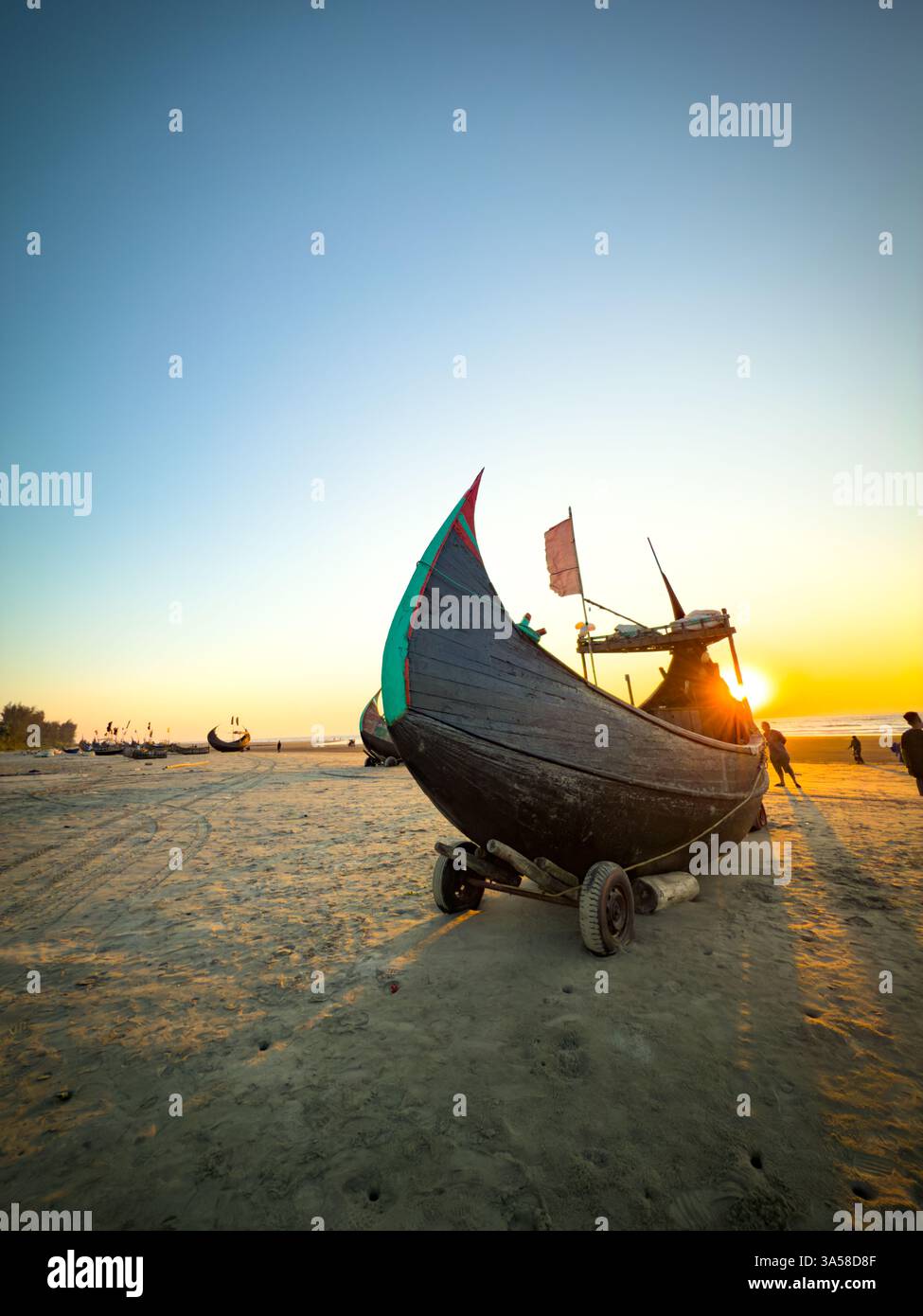 Traditional wooden fishing boat rests on the shore during a vibrant ...