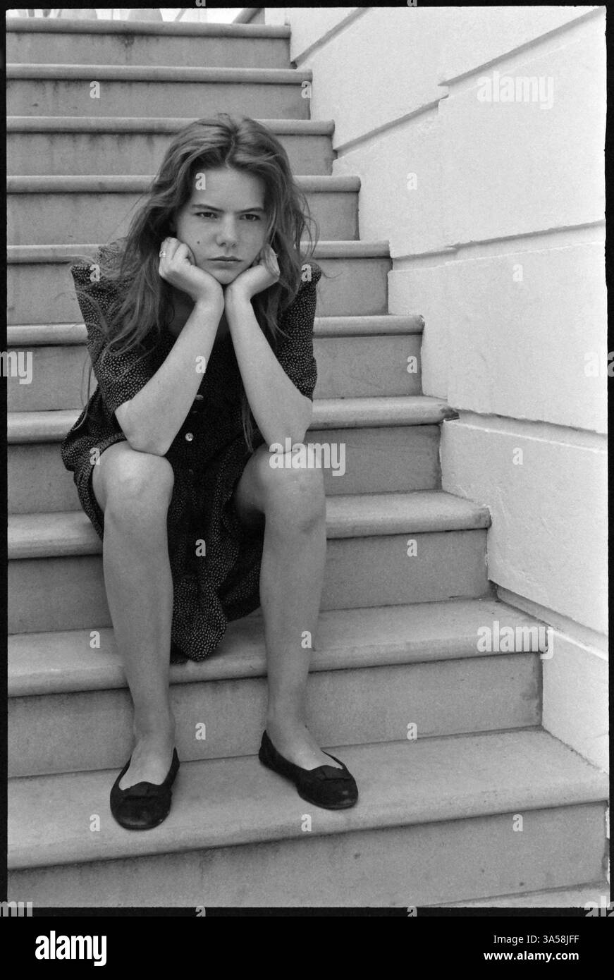 Young girl sitting on steps sulking in thought Stock Photo