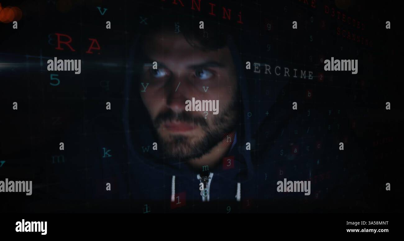 Man in hoodie surrounded by digital code, focusing on cybersecurity tasks Stock Photo