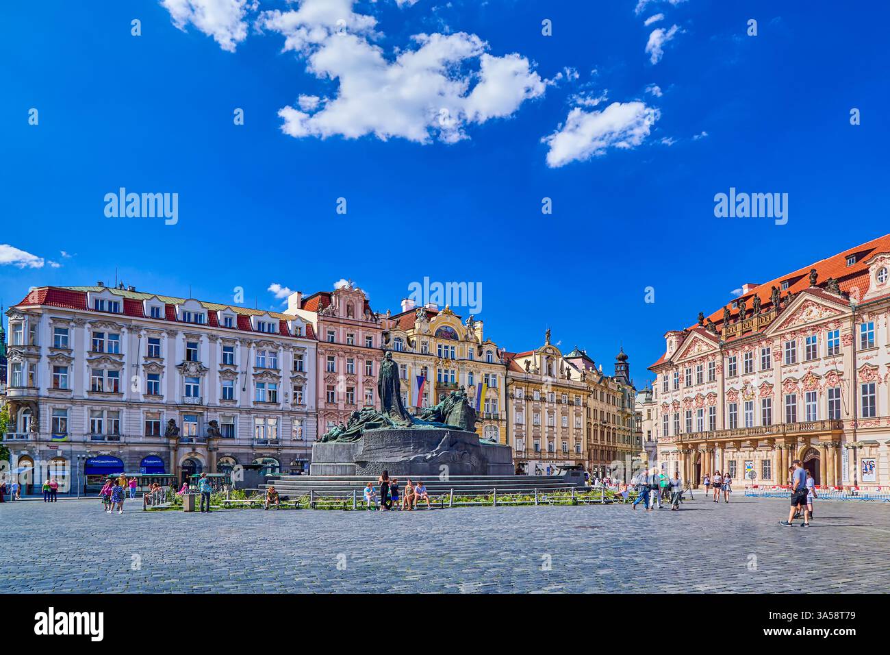 The Jan Hus Memorial is over 100 years old stands at one end of Old Town Square with row of coloured houses in background, Prague, Czech Republic Stock Photo