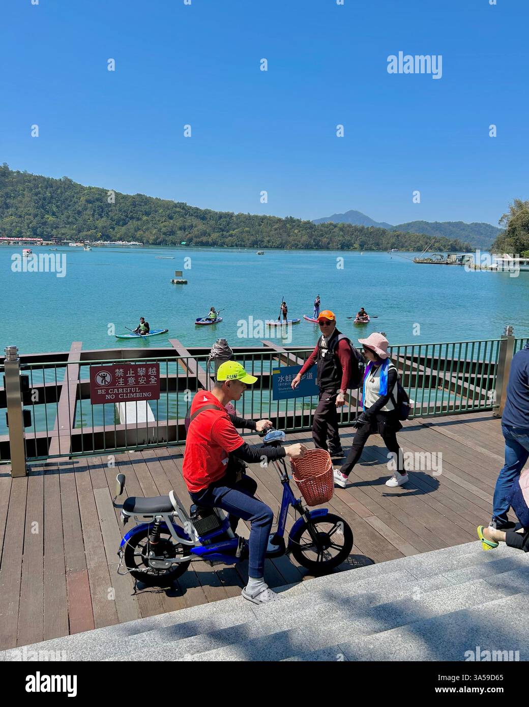 Yuchi, Taiwan, Group People Tourists, Visiting Tourist Region, 'Sun Moon Lake', Man on Rented Motorscooter - Smartphone Captured Stock Image