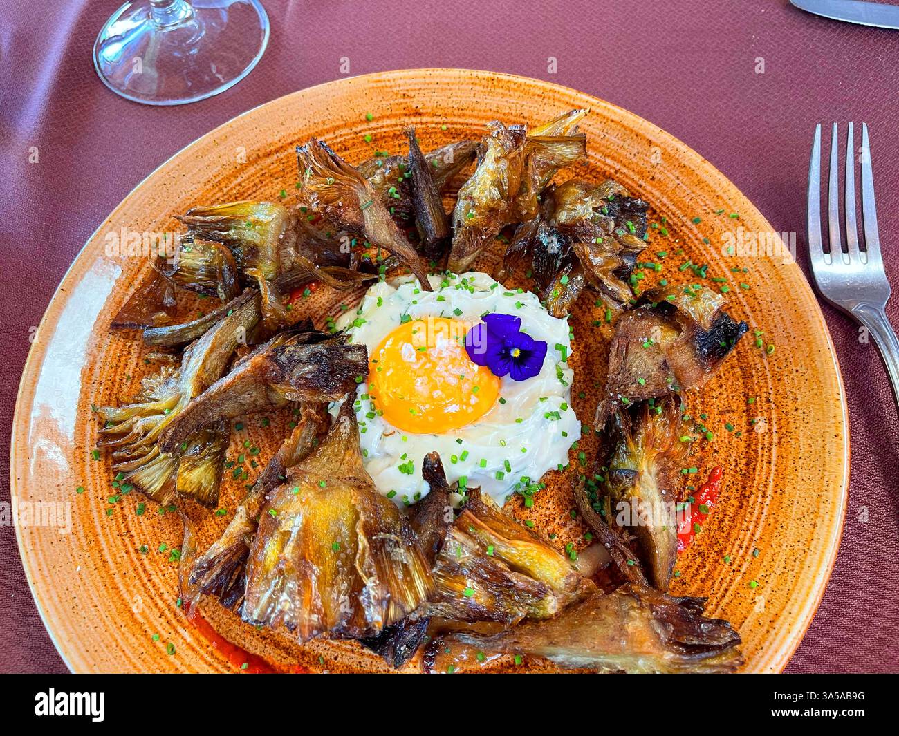 Fried artichokes with yolk and cheese as fried egg. Spain. - Smartphone Captured Stock Image