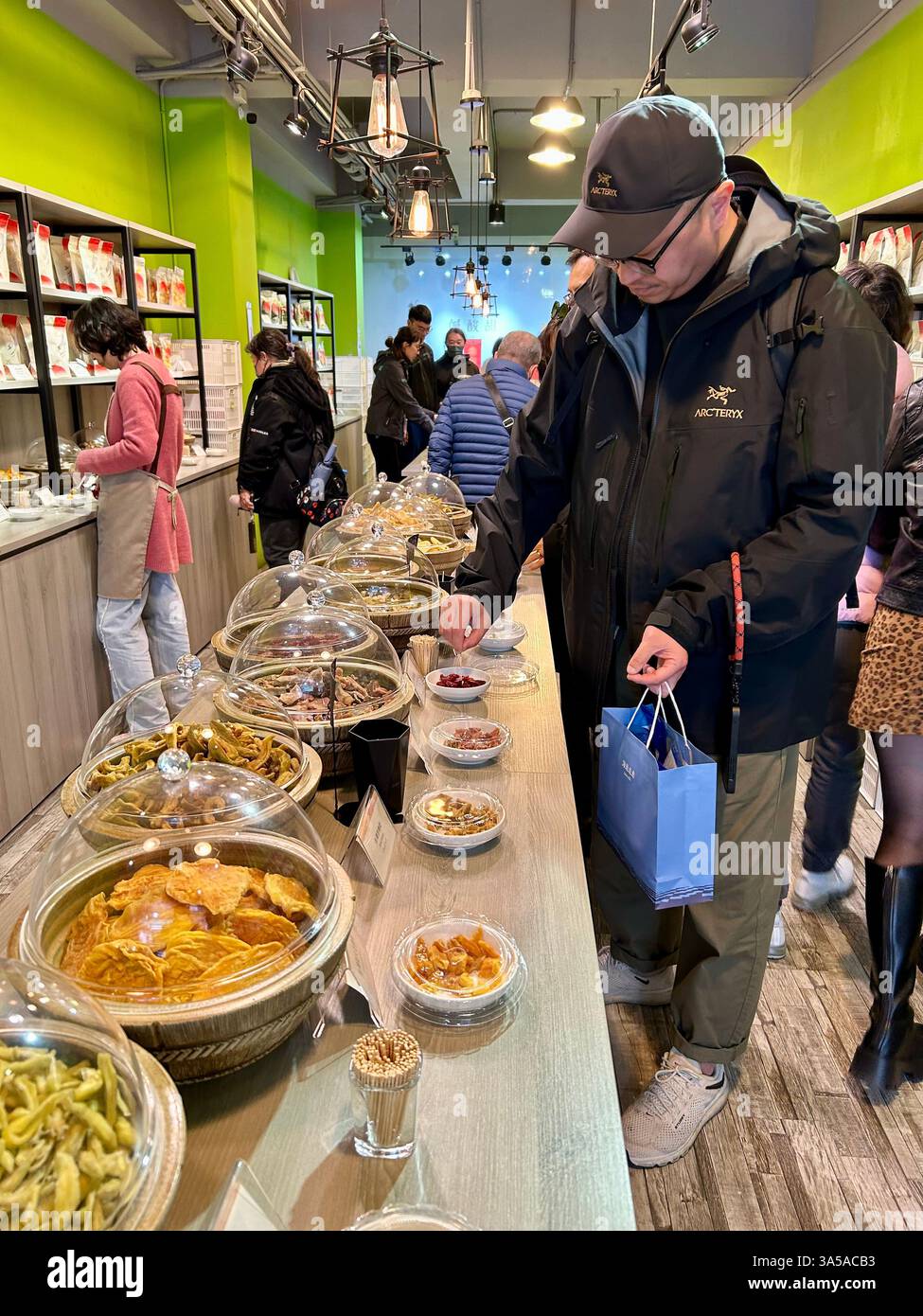 New Taipei, Taiwan, People, man, Tourists Shopping, Local Products, Visiting Old Street Stores, Tamsui District, Trying Food Samples - Smartphone Captured Stock Image