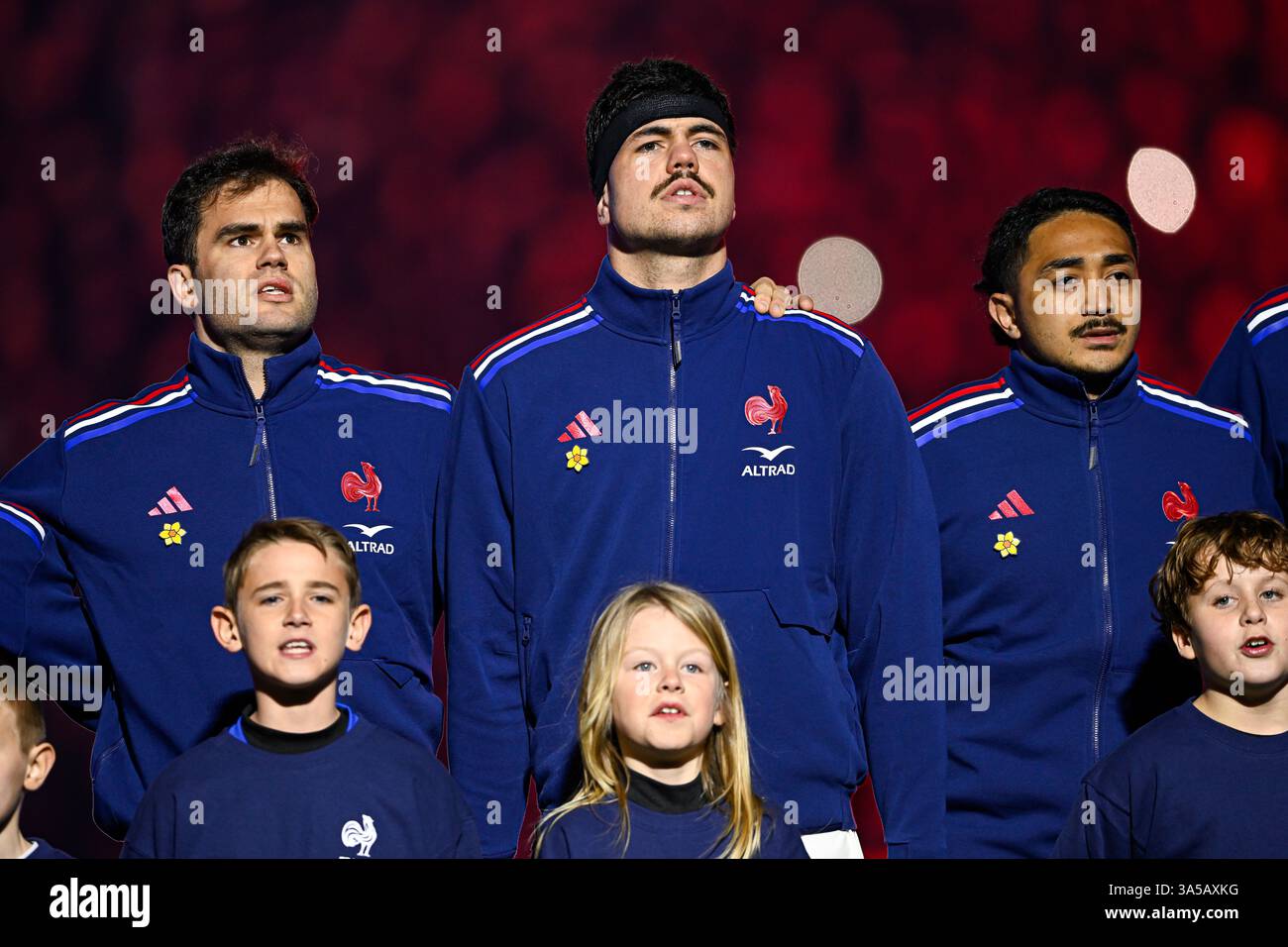 Young rugby players like Yoram Moefana, Damian Penaud, and Hugo Auradou showcasing skill and teamwork during a high-stakes match in Paris, March 2025