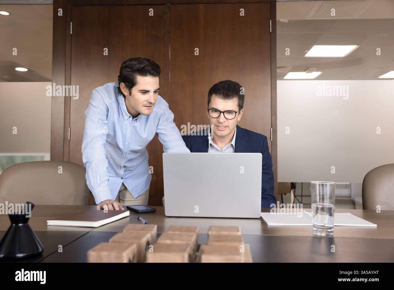 Two workmates reviewing important data, documents, or presentations using laptop Stock Photo