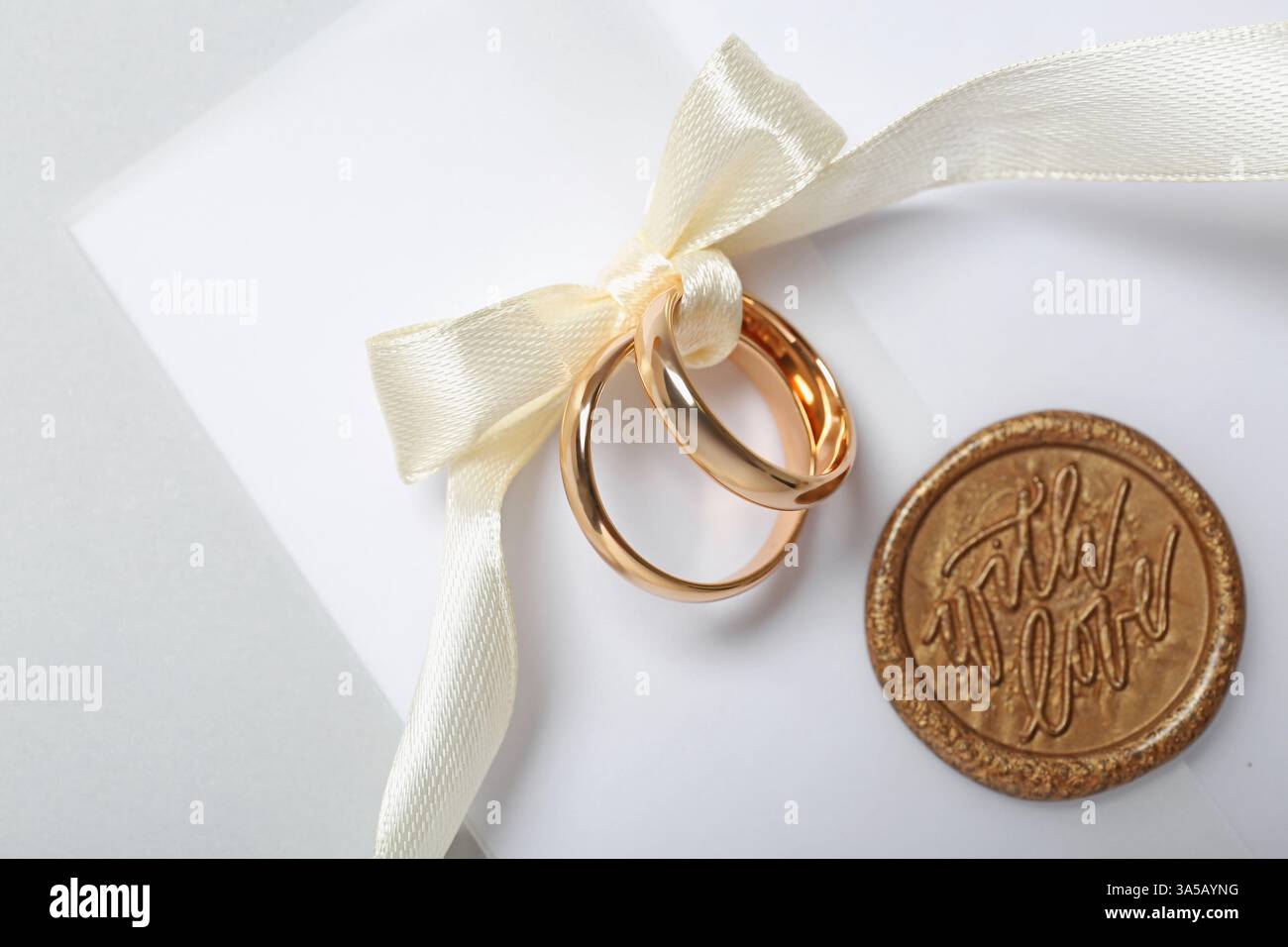Tyed Weding Rings Wedding rings tied with ribbon and love letter on light background, top ...