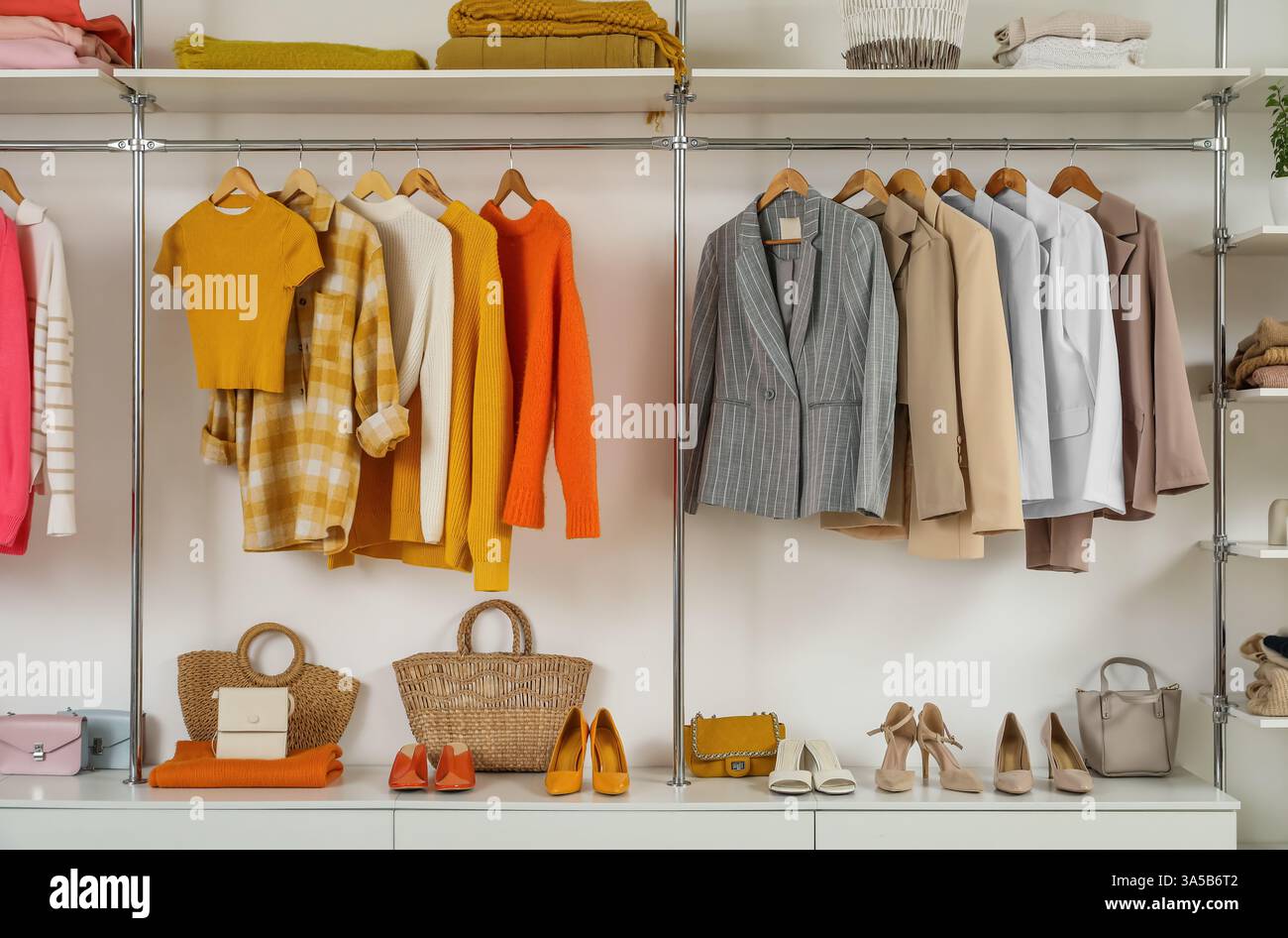 Wardrobe with female clothes and accessories in walk-in closet Stock Photo