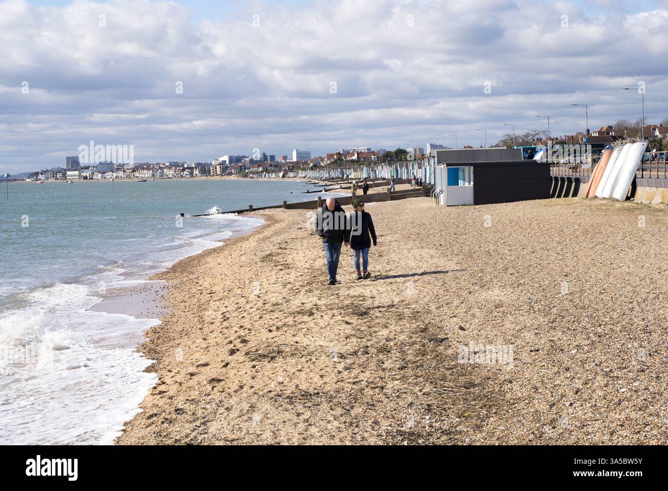 couple walk along pebbled beach at Southend-on-sea Essex England UK Stock Photo
