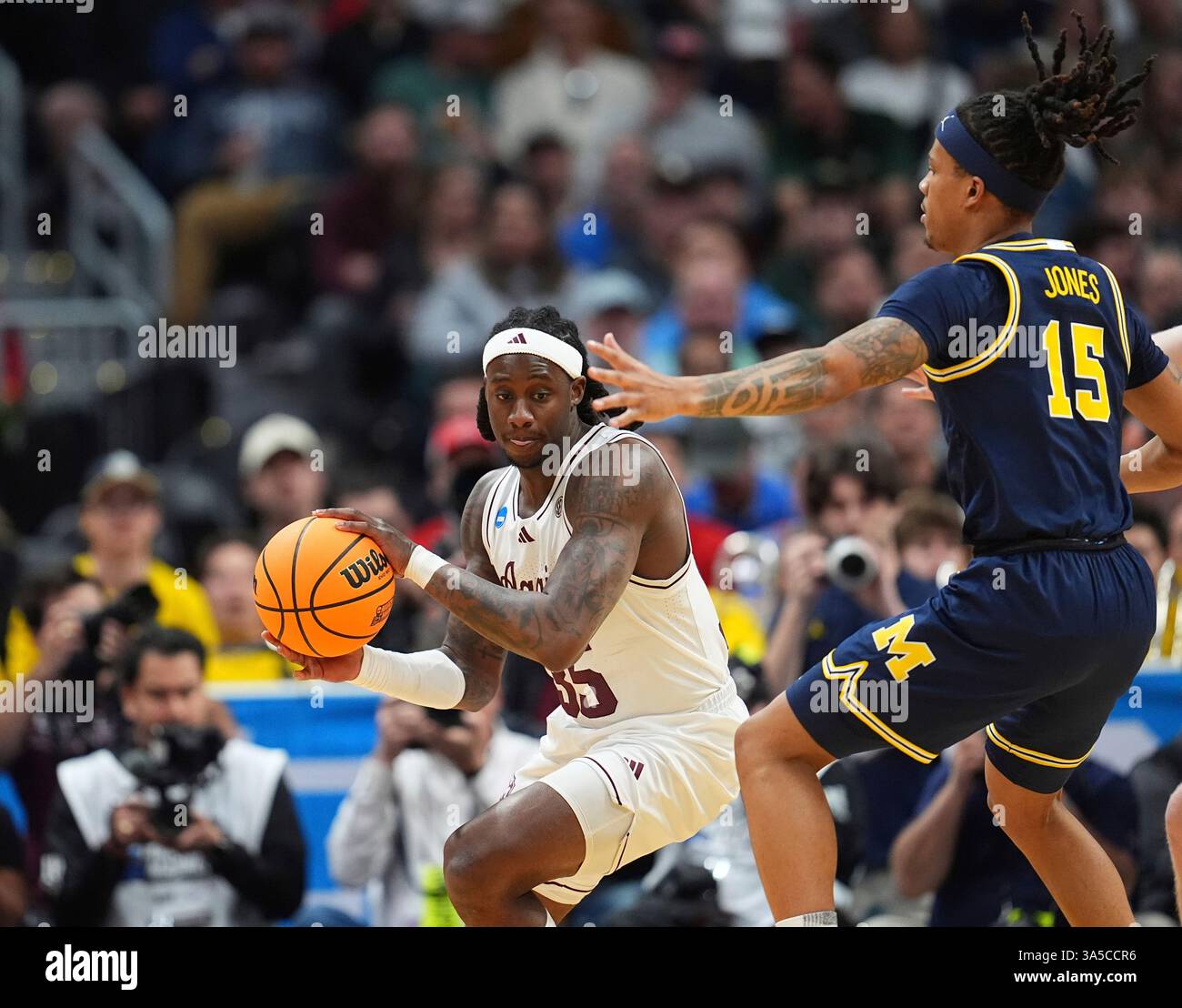 Texas A&M guard Manny Obaseki, left, passes the ball as Michigan guard ...