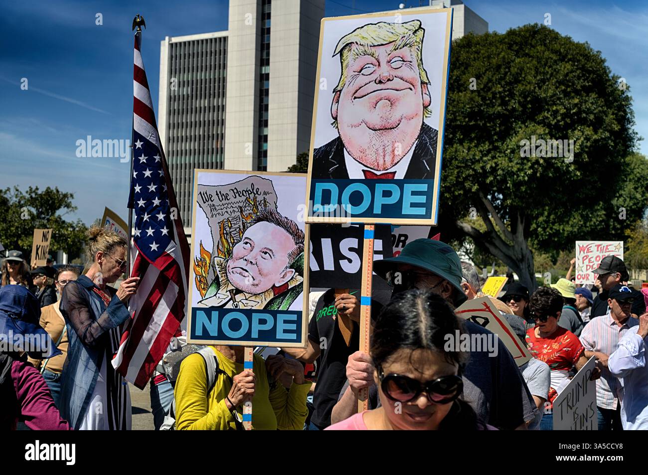 Protesters carry signs and chant slogans in protest to the policies of ...