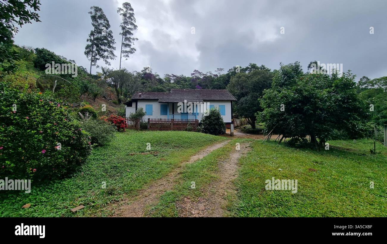 A charming countryside house with traditional architecture stands peacefully amidst lush nature. - Smartphone Captured Stock Image